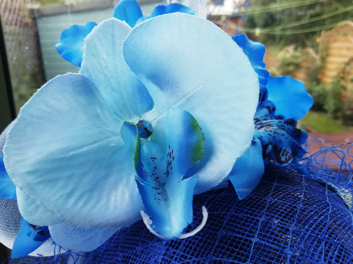 Blue orchids on blue fascinator with veiling